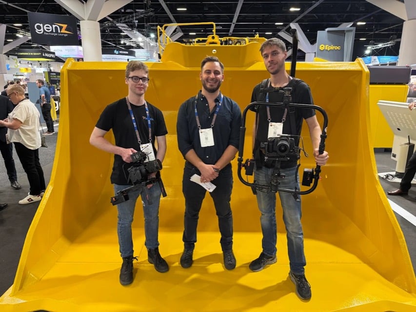 Viewix crew filming at a trade expo with a large excavator bucket